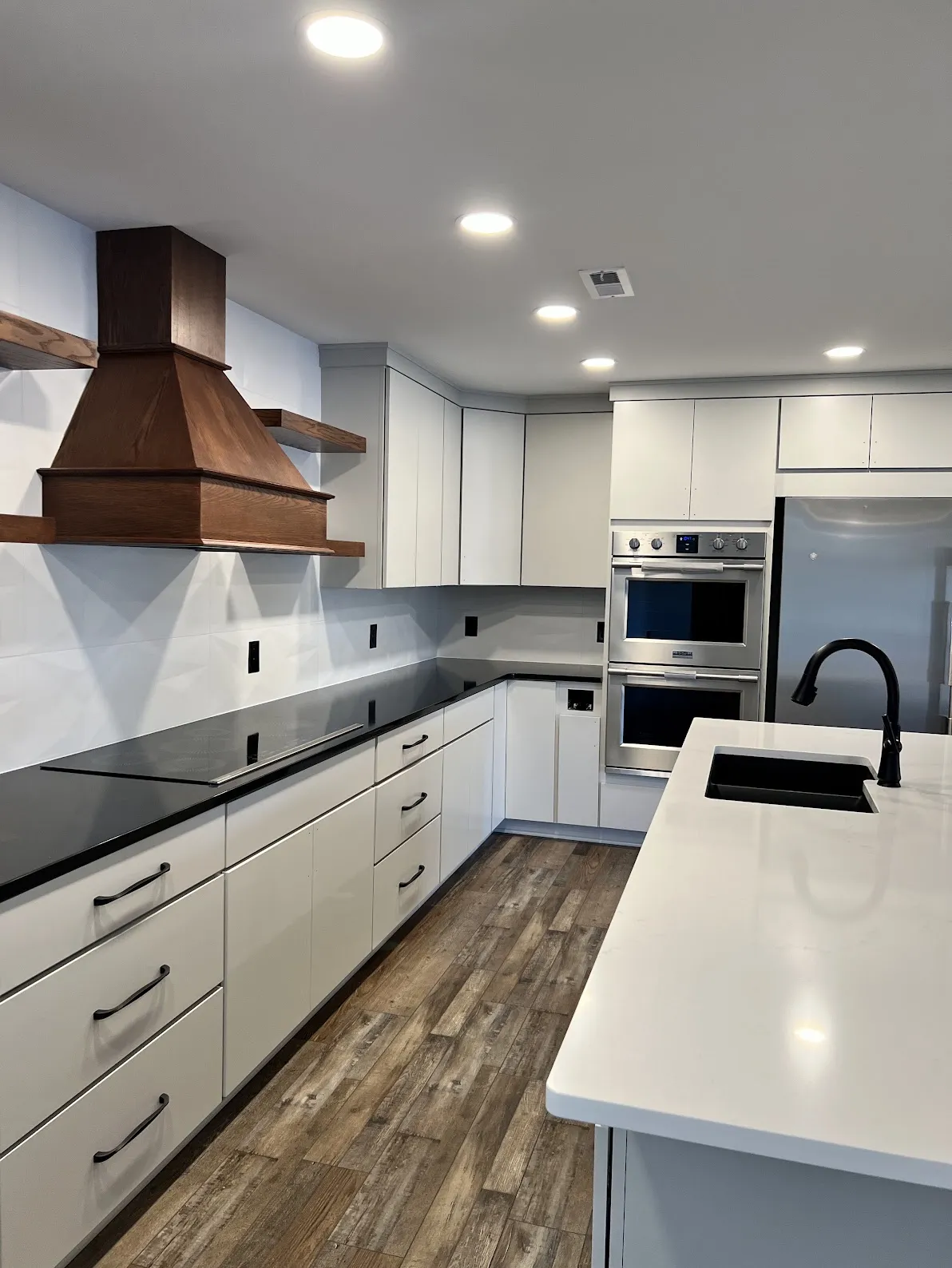 Bright kitchen remodel with wood range hood and waterfall quartz island