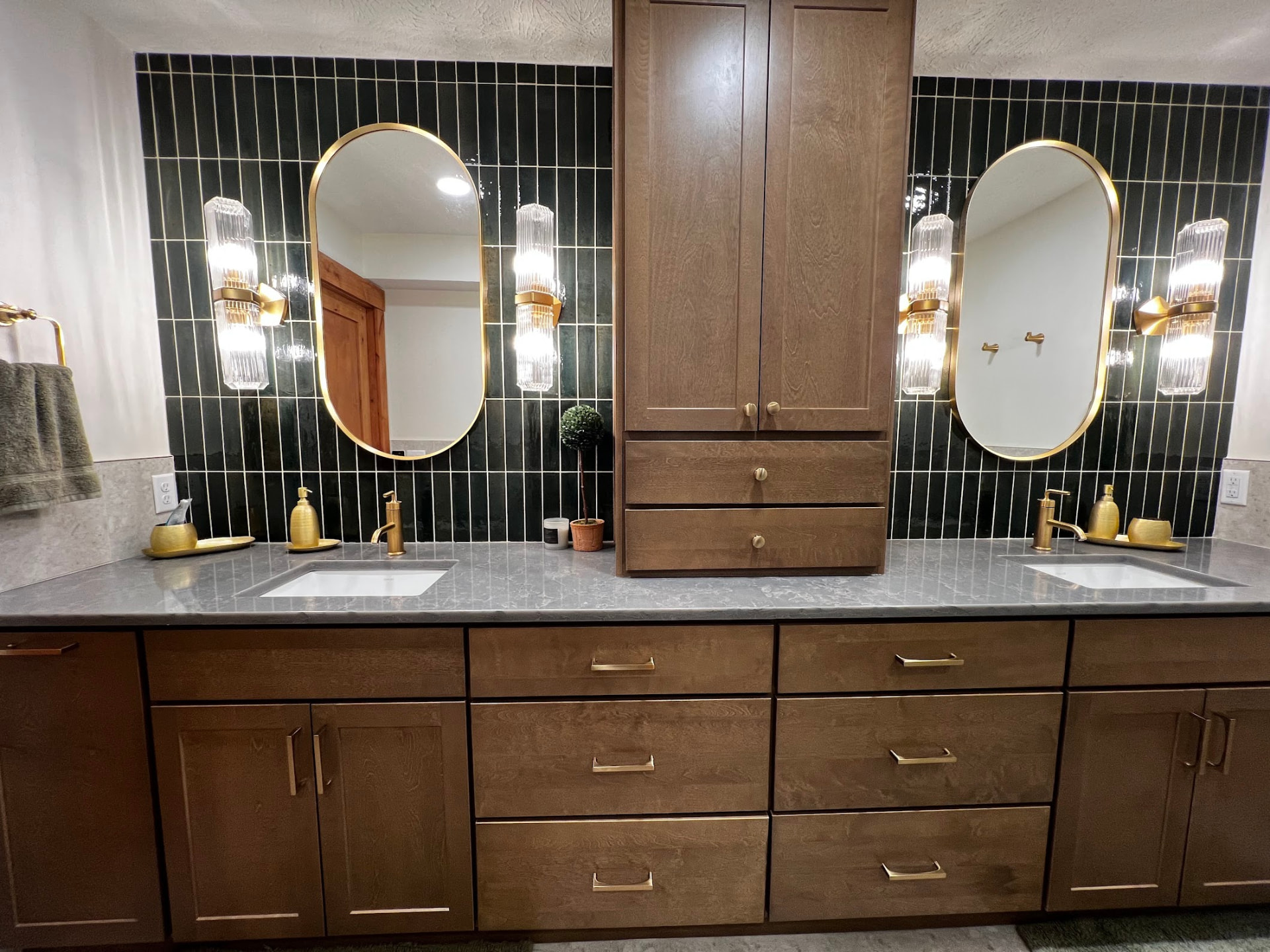 Primary bathroom remodel with double vanity, alder cabinetry, dark tile, and gold-framed mirrors